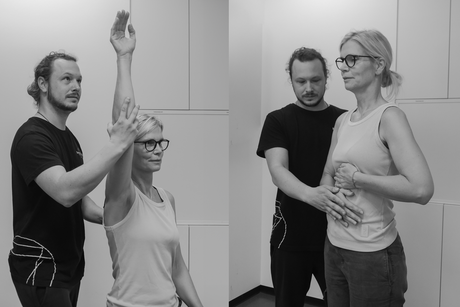 Frau bei Atemübungen neben Physiotherapeut